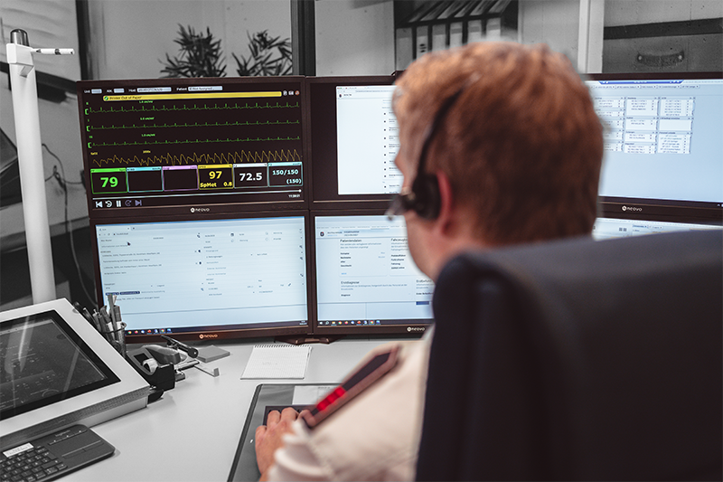 Ein Telenotarzt sitzt an einem TNA Platz und bedient einen Teil der docYou tna Software