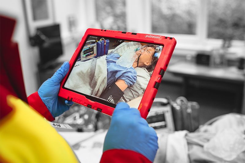Ein Mitarbeiter des Rettungsdienstes benutzt die docYou App um eine Patientin zu fotografieren