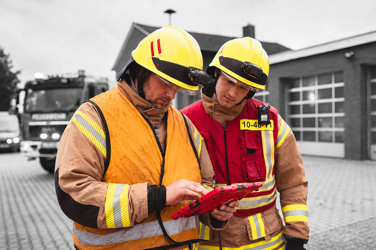 Zwei Mitarbeiter der Feuerwehr stehen vor einer Wache und bedienen docYou fire auf einem iPad