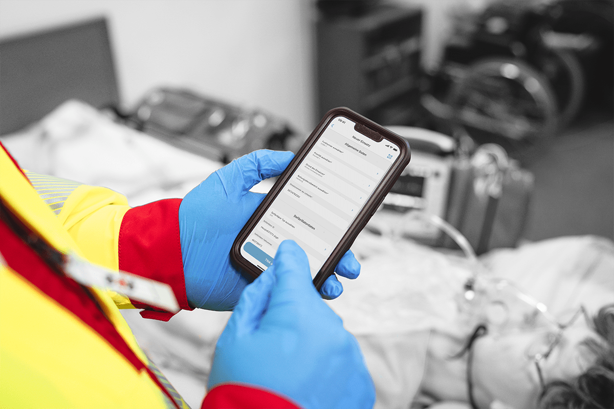 Ein Mitarbeiter des Rettungsdienstes bedient docYou tna auf dem Smartphone